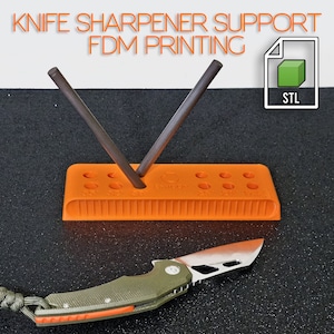Può includere: Supporto per affilacoltelli stampato in 3D di colore arancione con due aste metalliche e un coltello. Il supporto presenta una serie di fori e una superficie testurizzata. File STL incluso.
