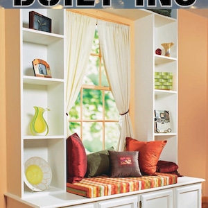 May include: A white built-in window seat with a striped cushion and red, green, and brown throw pillows. The seat is flanked by white shelves with decorative items, including a vase, a plate, and framed photos. The text "THE COMPLETE GUIDE TO BUILT-INS" is at the top of the image.