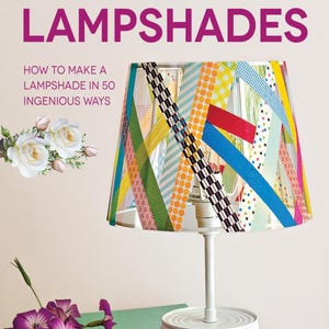 May include: A colorful DIY lampshade made with washi tape. The lampshade is on a white lamp base with a white can as the base. The text on the image reads "50 Thrifty DIY Lampshades How to make a lampshade in 50 ingenious ways."