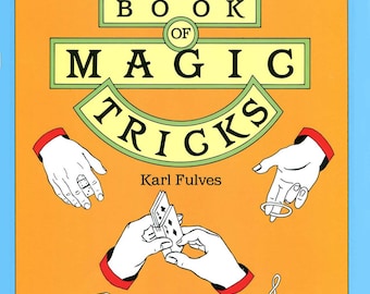 Może przedstawiać: Żółta okładka książki z tytułem "BIG BOOK OF MAGIC TRICKS" w czarnych i zielonych literach. Imię autora, "Karl Fulves", jest wydrukowane czarnym kolorem pod tytułem. Okładka zawiera ilustracje dłoni wykonujących magiczne sztuczki, w tym sztuczkę z pierścieniem, sztuczkę z kartami i sztuczkę znikającą.