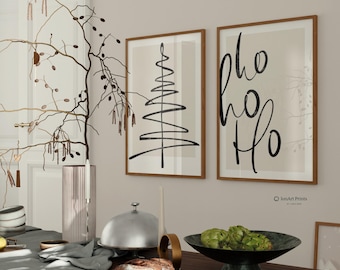 Puede incluir: Dos impresiones enmarcadas en una pared beige. La impresión de la izquierda es un dibujo en blanco y negro de un árbol de Navidad. La impresión de la derecha tiene el texto "Ho Ho Ho" en escritura negra sobre un fondo beige.