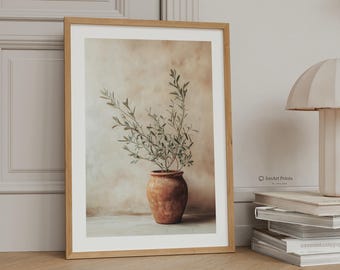 May include: A framed wall art print featuring a terracotta pot containing an olive branch with green leaves against a textured beige background. The print is housed in a light wood frame, with the text IonArt Prints visible on the lower right side.