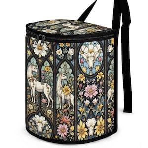 Pode incluir: Saco de almoço cilíndrico isolado com zíper preto e alça preta ajustável. A bolsa apresenta um design de vitral com veados brancos, flores e padrões florais em tons variados.