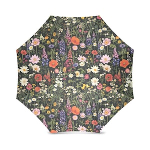 May include: An open umbrella with a dark background and a vibrant floral pattern. The design features a variety of colourful wildflowers, including poppies, daisies, and lupins, in shades of pink, orange, purple, and white.