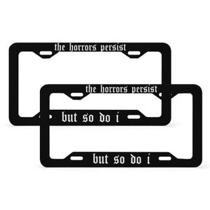 May include: Two black metal licence plate frames with the text "the horrors persist but so do i" in white gothic font.
