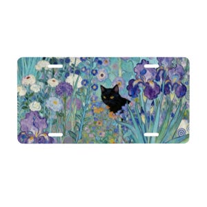 May include: License plate featuring a black cat peeking out from a vibrant floral garden. The artwork showcases irises and other flowers in shades of purple, blue, and white, set against a turquoise background. The plate has four mounting holes.