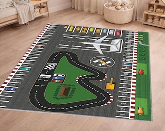 Puede incluir: Alfombra de juego rectangular para niños con diseño de pista de carreras y pista de aeropuerto. La alfombra tiene un fondo gris con líneas blancas, una pista de carreras verde y coches y vehículos de juguete coloridos. La alfombra está diseñada para el juego imaginativo.