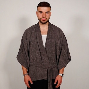 Może przedstawiać: Lekki, brązowy kimono o teksturalnej powierzchni, z długimi rękawami i paskiem do wiązania. Kimono wykonane jest z miękkiej, wygodnej tkaniny.