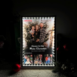 May include: A rectangular photo frame with a family portrait, illuminated by small white lights. The frame includes the text "FAMILYPIX" and "Home is the Main Character." Additional family photos are displayed below the main image.