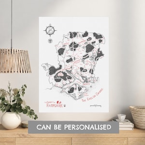Puede incluir: Una lámina de arte mural blanca con un mapa detallado en blanco y negro del condado de Hampshire. El mapa incluye una rosa de los vientos, ciudades etiquetadas, zonas boscosas y el Canal de la Mancha. Texto rojo resalta el título y lugares.