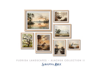May include: A collection of seven framed watercolor paintings depicting Florida landscapes. The paintings feature scenes of a lake with a boat, a horse in a field, a heron in a marsh, and a variety of trees and foliage. The paintings are all framed in natural wood frames. The text "FLORIDA LANDSCAPES - ALACHUA COLLECTION II" and "SAVANNA BLUE" is displayed below the paintings.