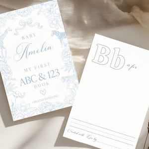 Könnte beinhalten: Ein blauer und weißer illustrierter Einband für ein erstes ABC- und 123-Buch für Babys. Der Einband zeigt ein florales Design mit Tieren, darunter eine Giraffe, ein Zebra und ein Elefant. Der Text auf dem Einband lautet "Baby Amelia, My First ABC & 123 Book, Created with Love".