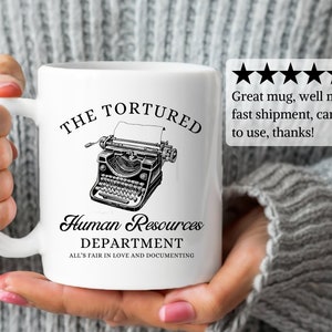 K&ouml;nnte beinhalten: Wei&szlig;e Keramik-Kaffeetasse mit einer Schwarzwei&szlig;-Illustration einer Vintage-Schreibmaschine mit dem Text "The Tortured Human Resources Department All's Fair in Love and Documenting".