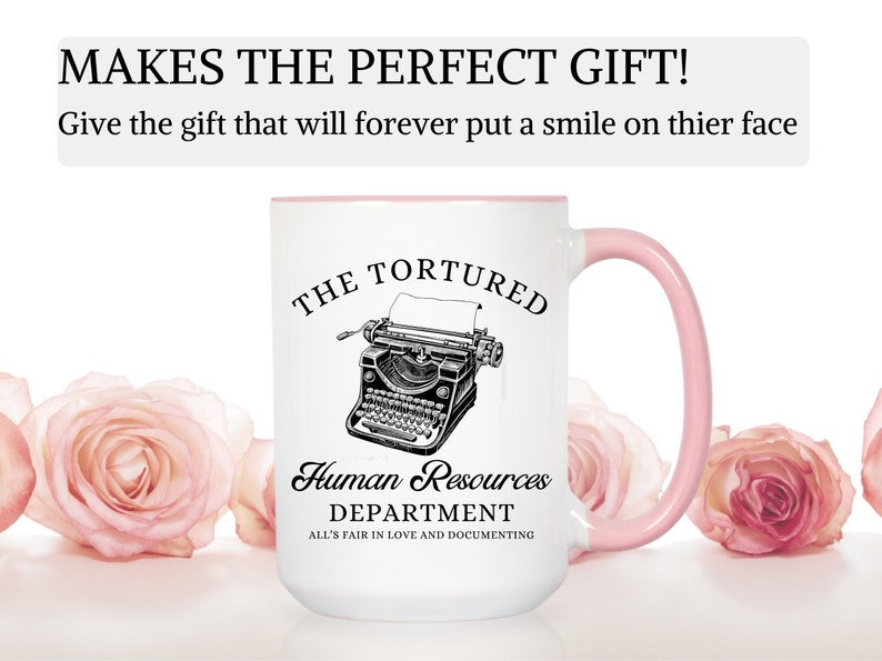 K&ouml;nnte beinhalten: Eine wei&szlig;e Keramik-Kaffeetasse mit rosafarbenem Rand und Henkel. Die Tasse zeigt eine Schwarzwei&szlig;illustration einer alten Schreibmaschine mit dem Text "The Tortured Human Resources Department All's Fair in Love and Documenting".