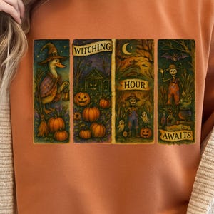 Può includere: Felpa arancione con grafica a tema Halloween. La grafica presenta quattro pannelli con illustrazioni di un'anatra strega, zucche, una casa infestata, uno spaventapasseri e le parole "Witching Hour Awaits."