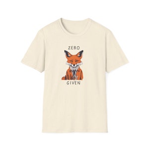 May include: A beige t-shirt with a graphic of a fox wearing a suit and tie. The text "ZERO GIVEN" is printed below the fox.