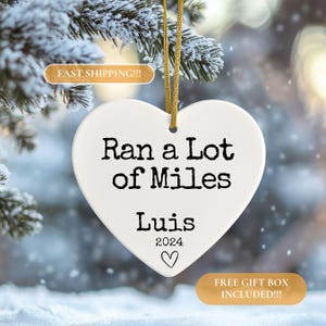 May include: White heart-shaped ceramic ornament with the text "Ran a Lot of Miles Luis 2024" and a small heart.