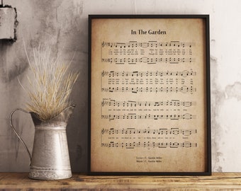 May include: A framed vintage sheet music print of the hymn "In The Garden" with lyrics and music by C. Austin Miles. The print features a brown background with black text and musical notation.