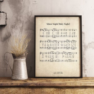 May include: A vintage-style printable art print featuring the sheet music for the Christmas carol "Silent Night! Holy Night!" The lyrics are by Joseph Mohr and the music is by Franz Gruber. The print has a cream background with black text and musical notes.