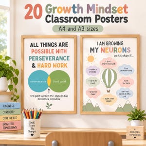Puede incluir: Dos pósteres educativos enmarcados titulados 20 Growth Mindset Classroom Posters en tamaños A4 y A3. El póster izquierdo muestra un diagrama de Venn sobre la perseverancia y el trabajo duro. El derecho muestra un globo aerostático con frases de mentalidad de crecimiento. Un portalápices con el texto Small Steps Big Changes se sitúa delante.
