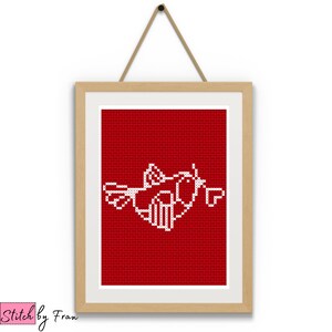 May include: A framed cross-stitch artwork featuring a white bird design on a red background. The artwork is displayed in a light brown wooden frame and is suspended by a beige string. The artwork is labeled "Stitch by Fran" in the lower left corner.