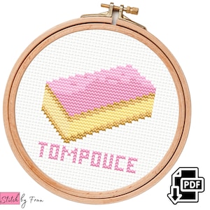 Op de afbeelding: Borduurpatroon van een roze en geel dessert genaamd "Tompouse" in een houten borduurring. Het patroon is beschikbaar als PDF-download.