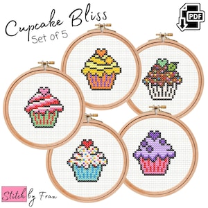 Pode incluir: Conjunto de cinco padrões de ponto cruz com cupcakes coloridos com diferentes coberturas. Os padrões estão em aros de bordado e o título "Cupcake Bliss Set of 5" está na parte superior da imagem.