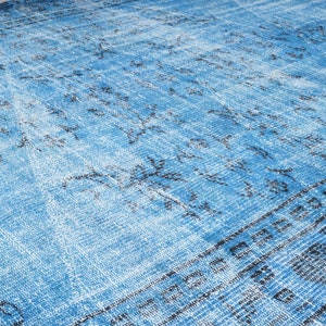 May include: A blue and white distressed rug with a geometric pattern. The rug has a faded look and a soft texture.