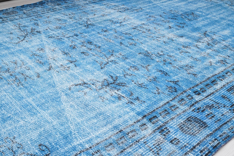 May include: A blue and white distressed rug with a geometric pattern. The rug has a faded look and a soft texture.