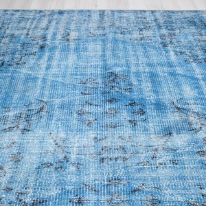 May include: A blue and black distressed rug with a faded pattern. The rug has a vintage look and feel.