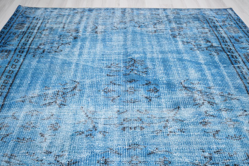 May include: A blue and black distressed rug with a faded pattern. The rug has a vintage look and feel.