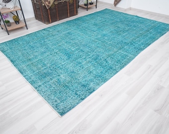 May include: A teal blue rug with a distressed, vintage look. The rug has a subtle pattern and is made of a soft, durable material.