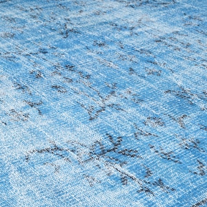 May include: A blue and white patterned rug with a distressed look. The rug has a faded blue background with a white pattern of lines and swirls.