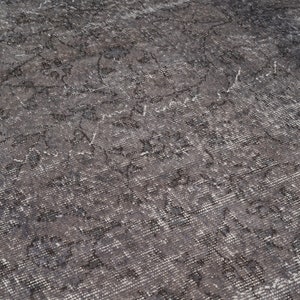 May include: A close-up of a gray and white patterned rug with a distressed, vintage look.