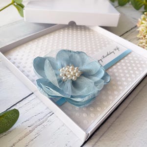 Karte zum Geburtstag für Sie. Handgefertigtes personalisiertes Geburtstagsgeschenk. Besondere handgefertigte Karte. Luxus Design, mit Schleife & großer Blume. Babyblau