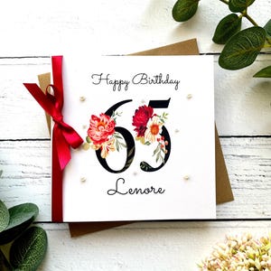 65e anniversaire | Personnalisé | Grands chiffres avec des fleurs | Ruban et noeud | Rouge et rose | Prénom féminin | Joyeux anniversaire | Perles