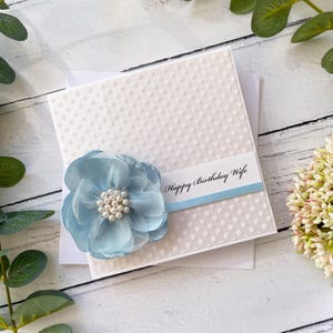 Karte zum Geburtstag für Sie. Handgefertigtes Geburtstagsgeschenk. Besondere handgefertigte Karte. Luxus Design, mit Schleife & großer Blume. Babyblau