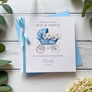 Nouvelle carte de bébé garçon, joli design vintage de landau, prénoms personnalisés des parents, nom du bébé et date de naissance. Un noeud et des fleurs à la main