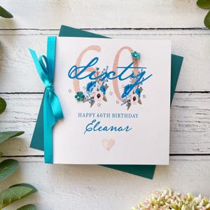 60er Jahre Geburtstagskarte für Sie. Hübsche handgemachte personalisierte Geburtstagskarte. Türkis und Weiß mit Schleife, Gems und Papierblumen.