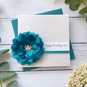 Karte zum Geburtstag für Sie. Handgefertigtes Geburtstagsgeschenk. Besondere handgefertigte Karte. Luxus Design, mit Schleife & großer Blume. Türkis