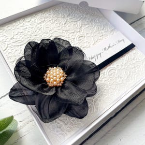 Carte de fête des mères. Cadeau fait main pour la fête des mères. Carte artisanale spéciale. Design luxueux, avec ruban et grande fleur. Fleur noire