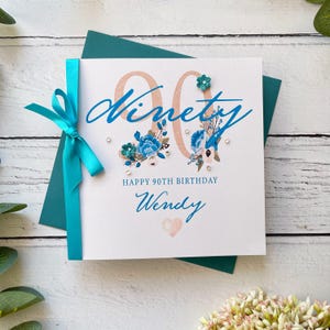 90er Geburtstagskarte für Sie. Hübsche handgemachte personalisierte Geburtstagskarte. Türkis und Weiß mit Schleife, Gems und Papierblumen.