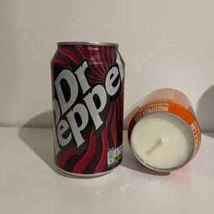 May include: A red and white Dr Pepper can candle with a white wick. The candle is in a clear glass jar with a red and white label that says "Multipack Can Not for resale"