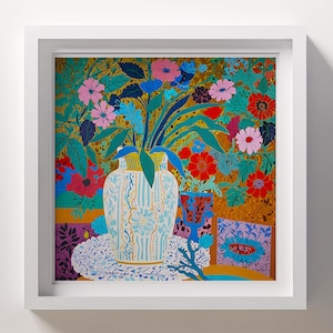May include: A white vase with blue and gold floral patterns holds a bouquet of pink, red, and blue flowers. The vase sits on a white doily on a table with a colourful patterned background.