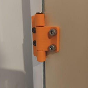 May include: An orange hinge with four silver screws is attached to a beige door. The hinge is made of a solid, possibly plastic, material and is designed to allow the door to swing open and closed. The hinge is mounted on the edge of the door.