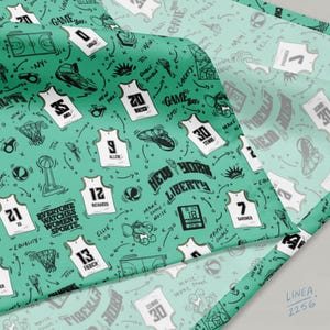 Puede incluir: Tela turquesa con temática de baloncesto. El diseño incluye camisetas de baloncesto, zapatos y garabatos relacionados con el juego. El texto incluye "New York Liberty", "Game Day" y "Everyone Watches Women's Sports".