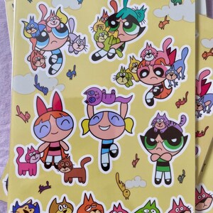 Feuille d'autocollants Catastrophe Chaos | Chats colorés inspirés de la nostalgie des dessins animés des années 90 - Jolies filles super-héros chibi rétro - Il pleut des chats