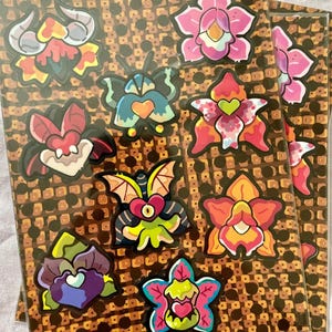 Feuille d'autocollants Cozy Grove monstrueuses orchidées – 9 autocollants en vinyle uniques | 4,5 x 6 pouces | Parfait pour les agendas, les journaux et les cadeaux - Flower Creepy Cute