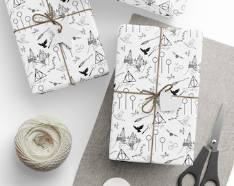 Könnte beinhalten: Weißes Geschenkpapier mit einem schwarz-weißen Muster aus einer Burg, Vögeln und anderen Symbolen. Die Geschenke sind mit Bindfaden gebunden und haben leere Anhänger. Ein Knäuel Bindfaden, eine Schere und leere Anhänger sind ebenfalls sichtbar.