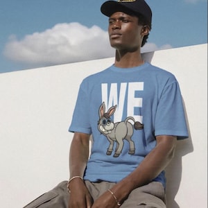 May include: A white ceramic mug with a black handle and the text "But First, Coffee" in a bold, black font. The mug is set against a blurred background, suggesting a cozy setting.